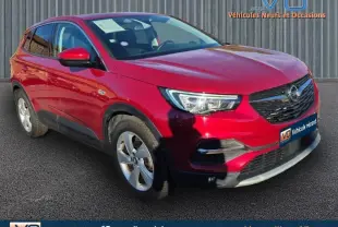 Opel Grandland X rouge foncé en 3/4 avant droit, mettant en valeur ses jantes alliage 17 pouces et sa calandre distinctive.