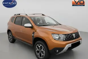 Dacia Duster ECO-G 100 4x2 Prestige orange vue 3/4 avant avec barres de toit et jantes alliage 17 pouces.
