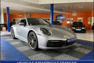 Porsche 911 (992) Carrera S argent GT vue 3/4 avant droit, jantes RS Spyder et intérieur noir visible en showroom