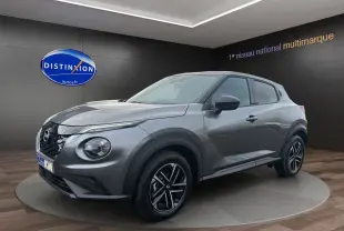 Nissan Juke Full Hybrid gris squale en 3/4 avant droit, avec jantes alliage noires et calandre distinctive.