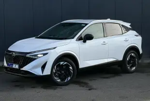 Nissan Qashqai blanc nacré en 3/4 avant droit, avec jantes alliage noires et toit contrasté noir.