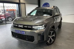 Vue 3/4 avant du Dacia Bigster gris schiste avec calandre noire et jantes alliage bicolores dans un showroom.