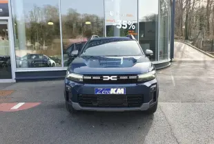 Vue frontale d’un Dacia Bigster bleu indigo avec signature lumineuse LED et toit panoramique visible.