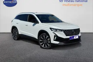 Vue 3/4 avant d'un SUV blanc avec jantes alliage noires et toit contrasté, stationné sur sol gris.
