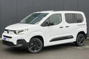 Vue 3/4 avant droit du Citroën Berlingo Multispace blanc Glacier avec jantes alliage noires et barres de toit.