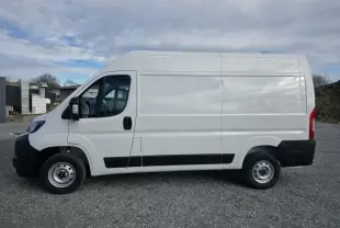 Vue latérale droite du fourgon blanc FIAT Ducato Tôlé 3.3 L H2 2025 avec roues acier et protections noires.