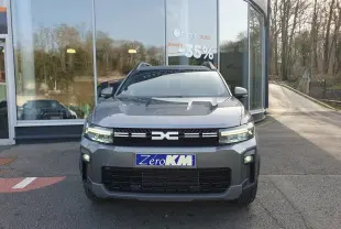 Vue avant d'un Dacia Bigster gris schiste avec signature lumineuse LED et toit panoramique visible en arrière-plan.