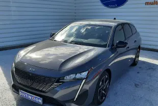 Peugeot 308 SW Hybrid gris sélénium métal vue 3/4 avant droit, avec calandre noire et feux LED verticaux distinctifs.