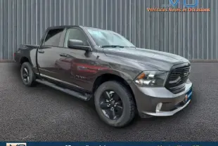 Vue 3/4 avant droit du Dodge RAM Crew SLT Classic Black gris foncé avec jantes noires et calandre sombre, 2022.