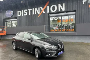 Renault Mégane DCI 130 noire vue en 3/4 avant droit sous la pluie devant un bâtiment avec enseigne Distinxion.