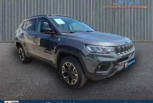 Jeep Compass Trailhawk gris foncé en 3/4 avant droit, mettant en valeur ses jantes spécifiques et sa calandre distinctive.