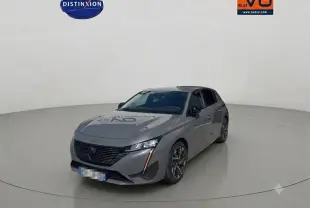 PEUGEOT 308 Hybrid gris vue 3/4 avant droit dans un studio, avec jantes alliage et phares LED allumés.