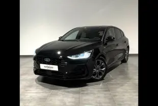 Ford Focus 2024 noir Agate métallisé vue 3/4 avant avec phares LED allumés dans un intérieur neutre.