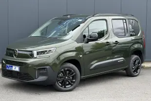 Vue 3/4 avant droite d'un Citroën Berlingo Multispace vert Sirkka avec jantes noires et barres de toit noires.