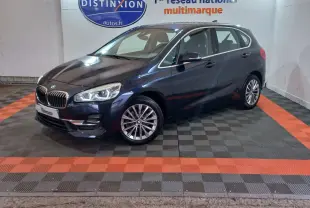BMW Série 2 Active Tourer 218d bleu vue 3/4 avant droit avec phares LED et jantes alliage en showroom