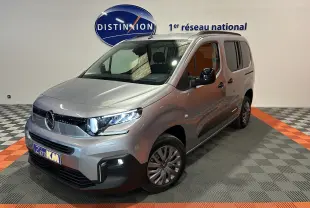 Citroën Berlingo Multispace gris acier en 3/4 avant droit, avec barres de toit noir brillant et phares LED allumés.