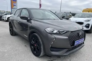 Vue 3/4 avant droite d'un DS3 Crossback gris platinium avec calandre distinctive et jantes noires brillantes.