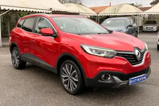 Renault Kadjar rouge flamme en 3/4 avant droit, mettant en valeur ses jantes bi-ton et ses optiques modernes.