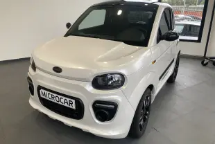 Microcar Dué Must DCI blanc nacré vu de 3/4 avant droit, avec jantes noires bicolores et phares arrondis.