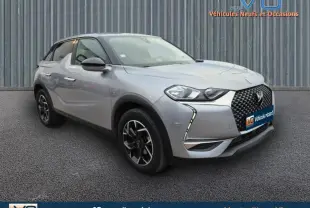 Vue 3/4 avant gauche d'un DS3 Crossback gris métallisé avec jantes alliage noires et calandre distinctive en losange.