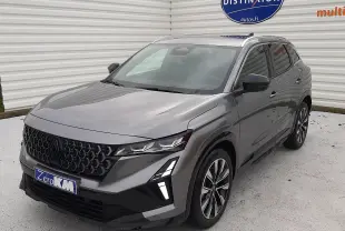 Renault Austral Ph.2 gris schiste en 3/4 avant droit, avec calandre noire distinctive et feux LED verticaux allumés.