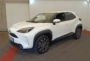 Toyota Yaris Cross blanc vue 3/4 avant droit, avec jantes alliage noires et protections plastiques noires.