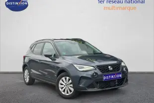 Vue 3/4 avant d'un SEAT Arona 2025 gris Magnétique Métal avec toit noir et jantes argentées, sur fond neutre.
