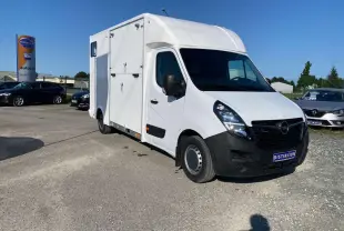 Vue 3/4 avant droit d'un Opel Movano Fourgon blanc avec capucine et portes latérales sur parking.
