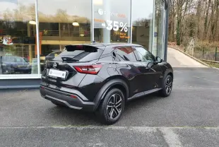 Vue 3/4 arrière droite du Nissan Juke noir métallisé 2025 avec jantes alliage 17'' et antenne aileron de requin.