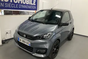 Aixam City Sport gris vue 3/4 avant droit avec jantes noires et calandre noire dans un showroom.