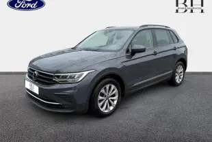 Volkswagen Tiguan 1.5 TSI gris dauphin métallisé vu en 3/4 avant droit avec jantes alu et barres de toit.