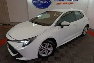 Toyota Corolla hybride blanche vue en 3/4 avant droit, avec phares LED et jantes alliage visibles.