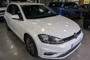 Volkswagen Golf VII TSI blanche vue en 3/4 avant droit dans un showroom avec jantes alliage et phares LED.