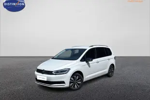 Volkswagen Touran blanc vue 3/4 avant droit, avec jantes alliage et vitres arrière surteintées.